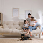 Happy,Family,On,Sofa,And,Puppy,In,Living,Room